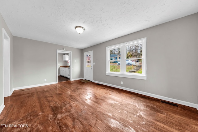 unfurnished room featuring hardwood / wood-style floors and a textured ceiling