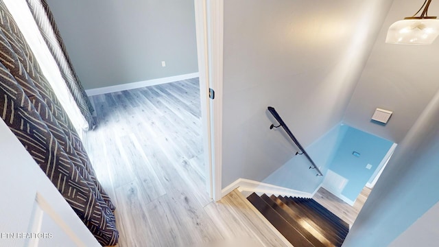 staircase with baseboards and wood finished floors