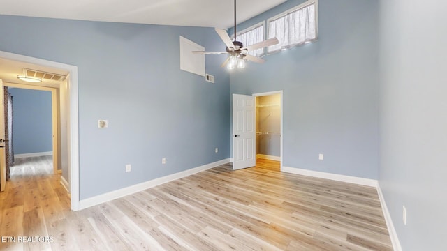 unfurnished bedroom featuring light wood-type flooring, visible vents, a spacious closet, and baseboards