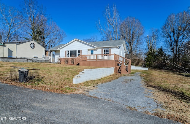 ranch-style house with a front yard and a deck