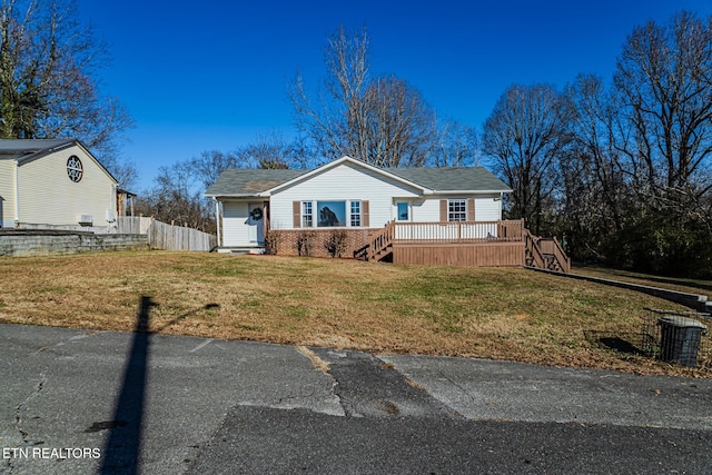 view of front facade featuring a front lawn and a wooden deck