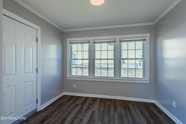 empty room featuring crown molding and dark hardwood / wood-style flooring