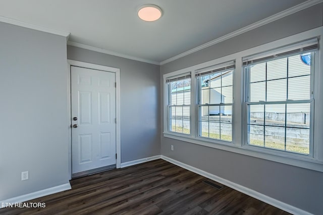 spare room featuring dark hardwood / wood-style flooring and crown molding