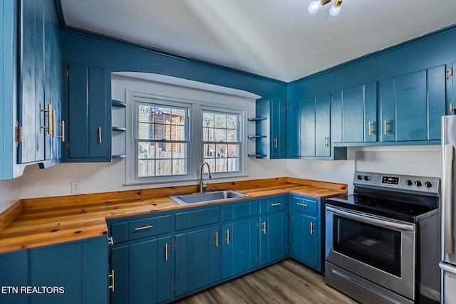 kitchen featuring butcher block countertops, blue cabinetry, stainless steel electric range oven, and sink