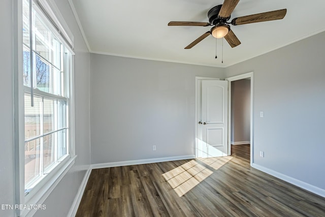 spare room featuring ceiling fan, ornamental molding, and dark wood-type flooring