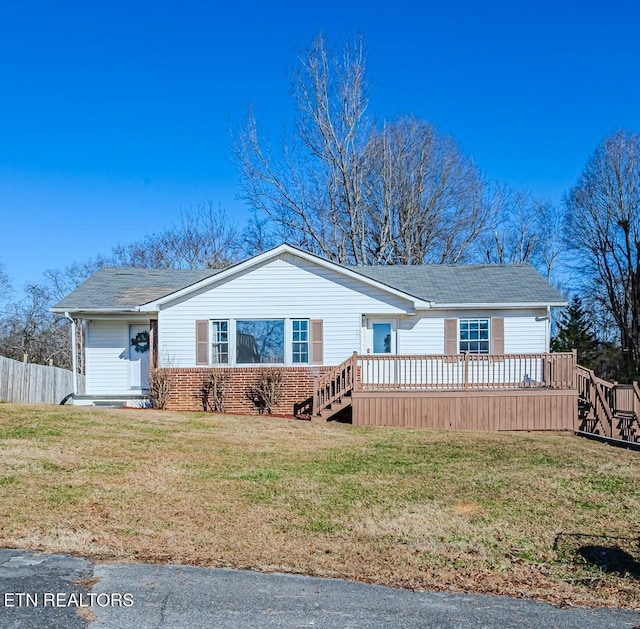 view of front of home with a deck and a front yard