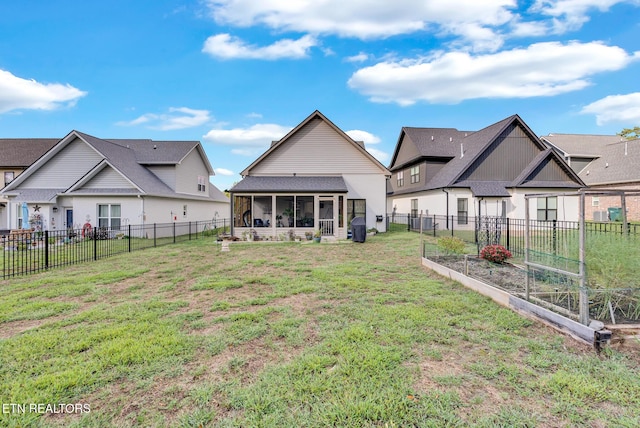 rear view of property with a sunroom and a yard