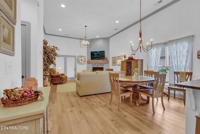 dining space featuring a chandelier, light wood-type flooring, and crown molding