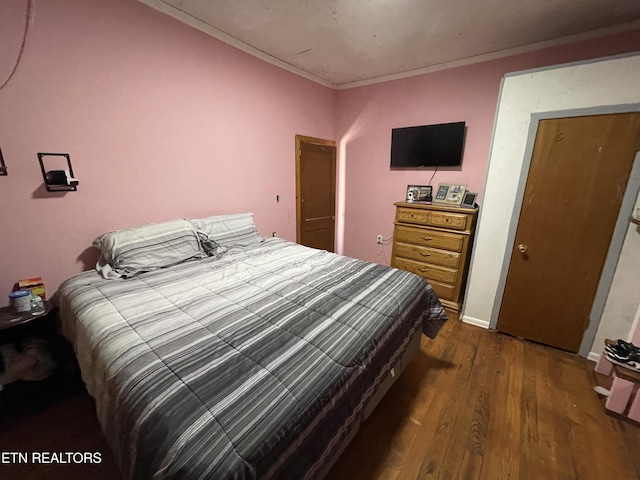 bedroom with dark hardwood / wood-style flooring and crown molding