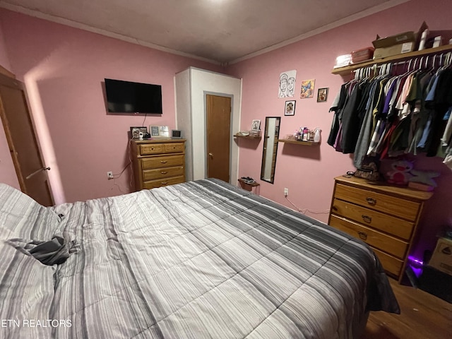 bedroom featuring ornamental molding and a closet