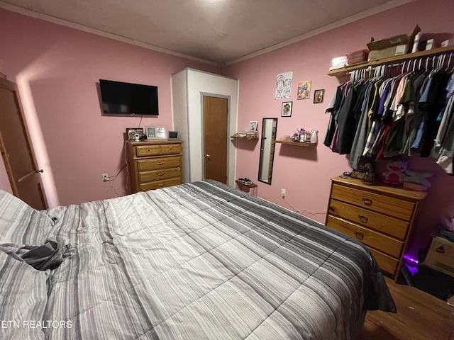 bedroom with crown molding and a closet