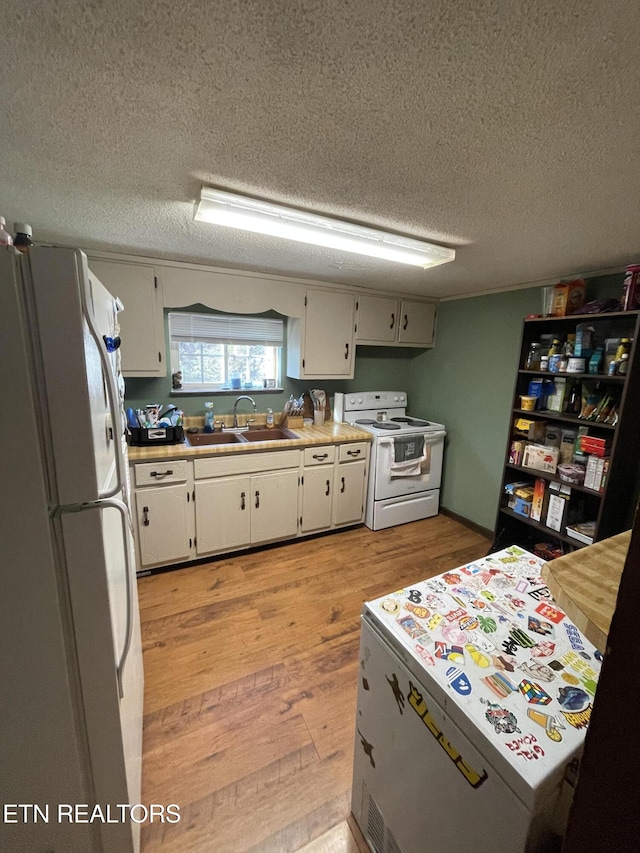 kitchen with a textured ceiling, white appliances, sink, white cabinets, and light hardwood / wood-style floors