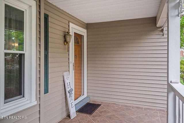 view of exterior entry featuring covered porch