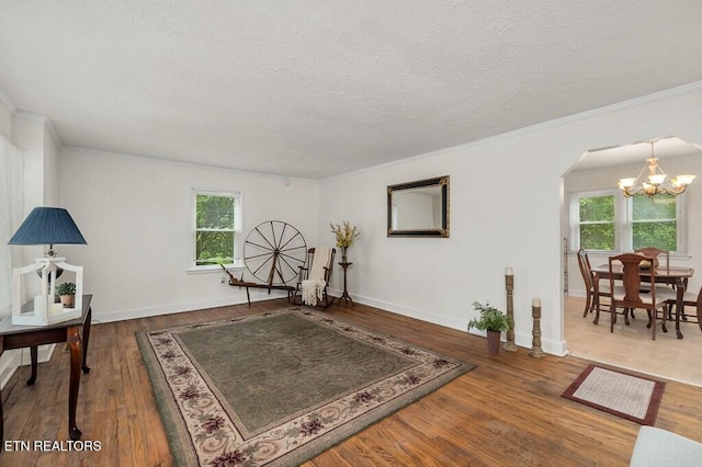 interior space with hardwood / wood-style floors, a notable chandelier, crown molding, and a textured ceiling