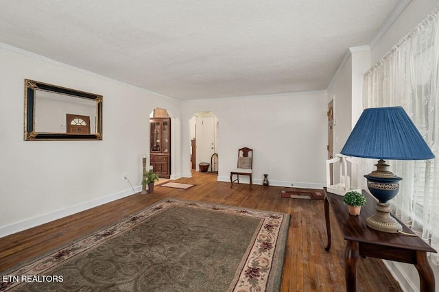 living area with hardwood / wood-style flooring and ornamental molding