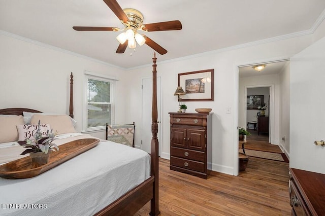 bedroom featuring hardwood / wood-style floors, ceiling fan, and crown molding