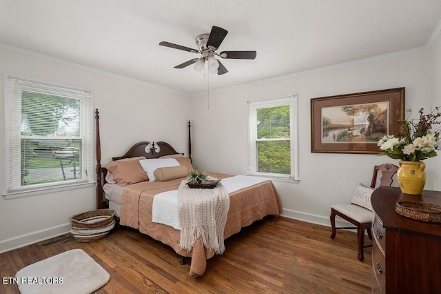 bedroom featuring multiple windows, dark hardwood / wood-style flooring, ceiling fan, and crown molding