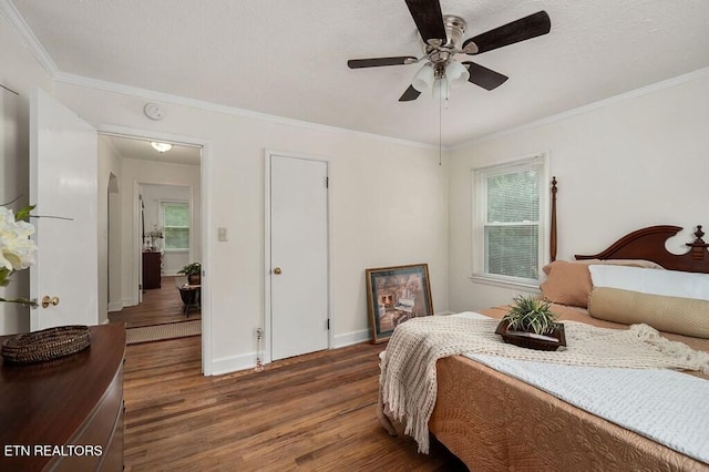 bedroom with ceiling fan, crown molding, and dark wood-type flooring