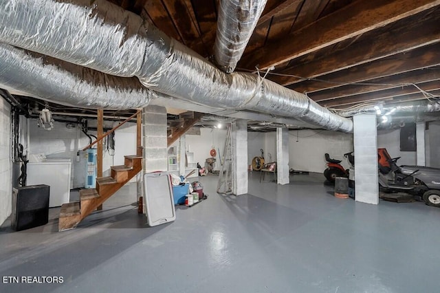 basement with electric panel and washer / dryer