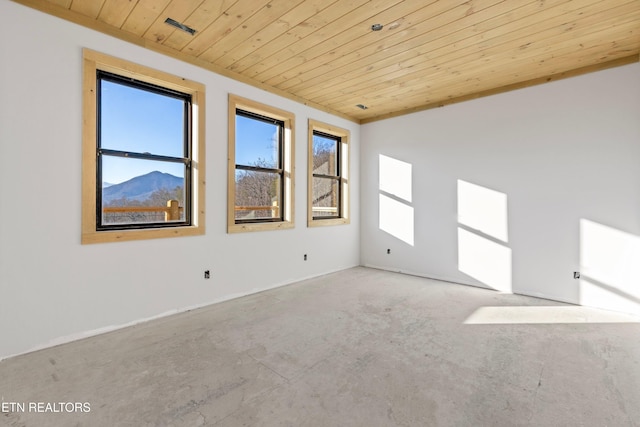 empty room featuring a wealth of natural light, a mountain view, and wooden ceiling