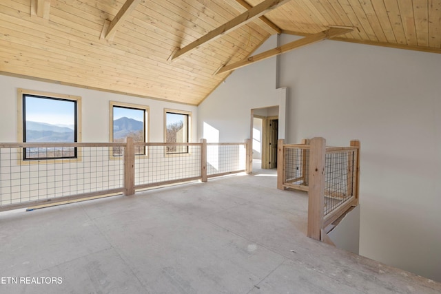 empty room featuring beam ceiling, a mountain view, high vaulted ceiling, and wooden ceiling