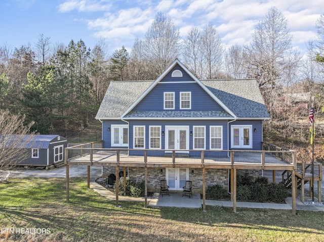 back of house with a lawn, french doors, a deck, a storage shed, and a patio area