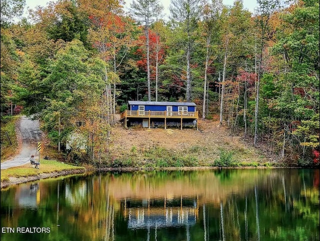 rear view of house featuring a deck with water view