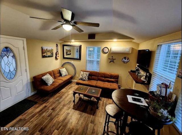 living room featuring ceiling fan, wood-type flooring, a wall unit AC, and vaulted ceiling