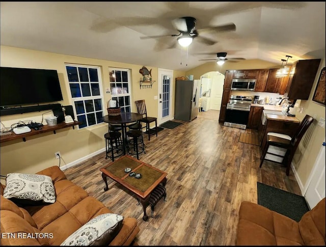 living room featuring ceiling fan, sink, wood-type flooring, and lofted ceiling