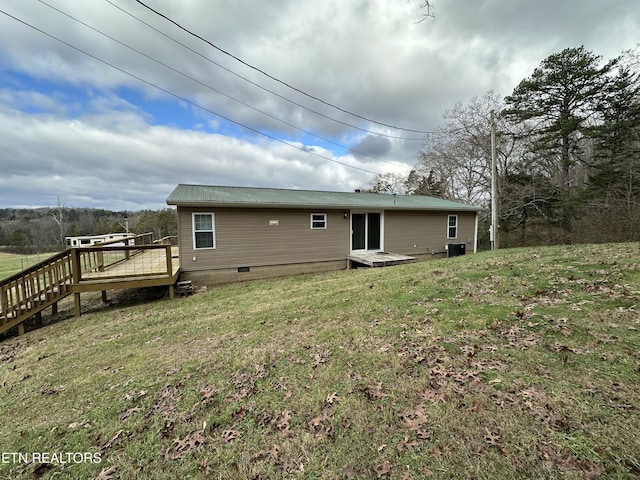 rear view of house featuring a deck and a yard