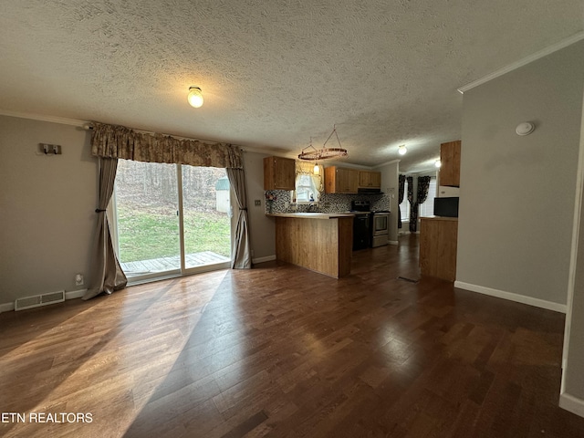 kitchen with stainless steel range, tasteful backsplash, dark hardwood / wood-style floors, ornamental molding, and kitchen peninsula