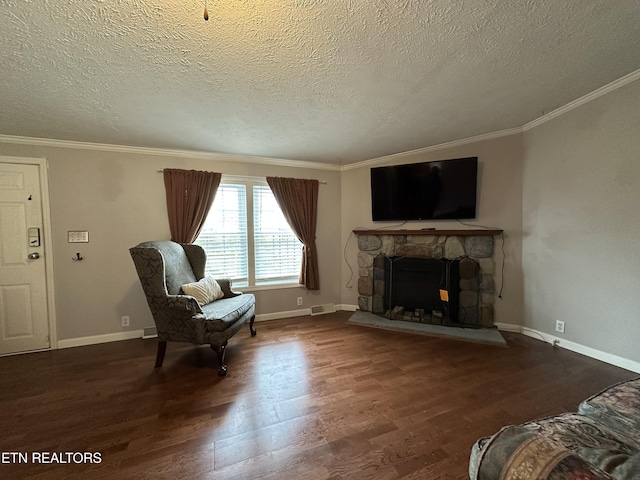 living area with dark hardwood / wood-style flooring, crown molding, a fireplace, and a textured ceiling