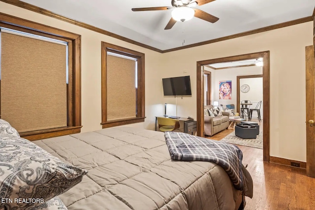 bedroom featuring ceiling fan, crown molding, and hardwood / wood-style flooring