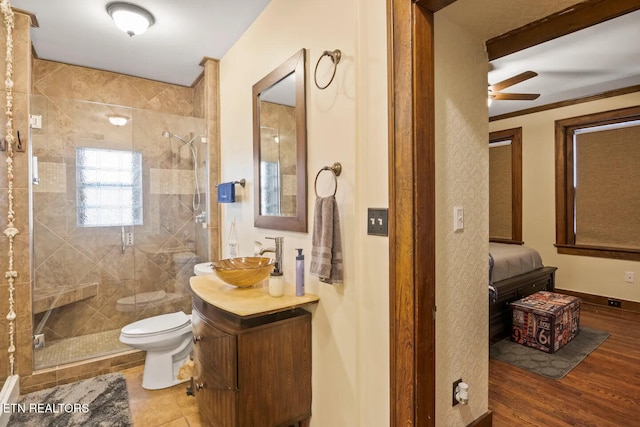 bathroom with an enclosed shower, vanity, ceiling fan, wood-type flooring, and toilet