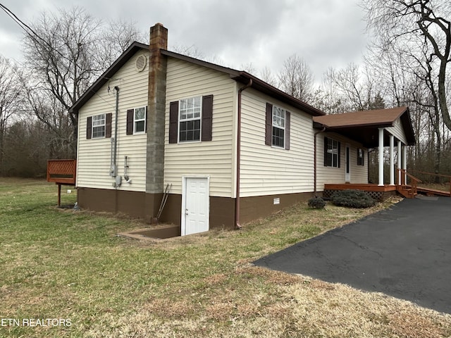 view of side of property with a porch and a lawn