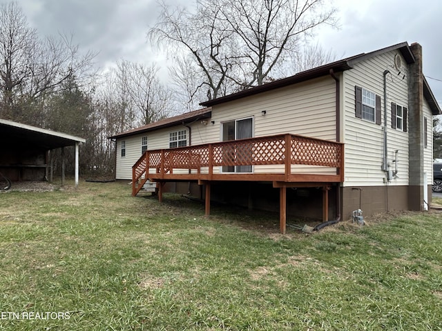 back of property with a yard, a carport, and a deck