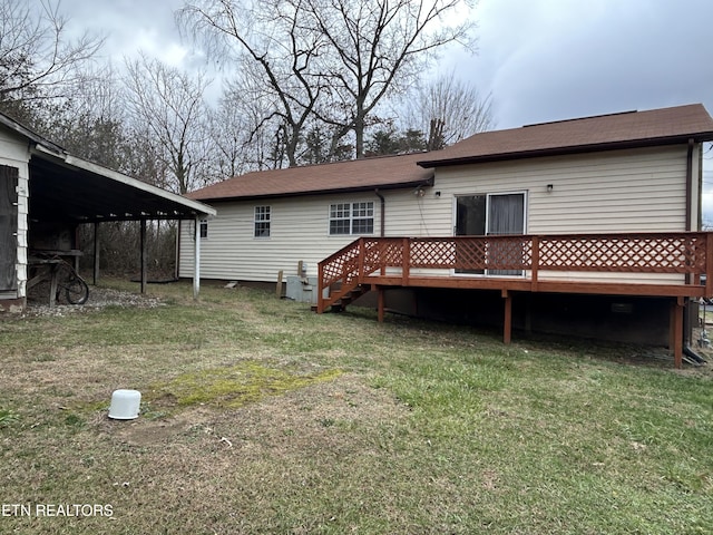 back of house featuring a wooden deck and a lawn