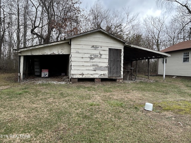 view of outbuilding with a carport and a lawn