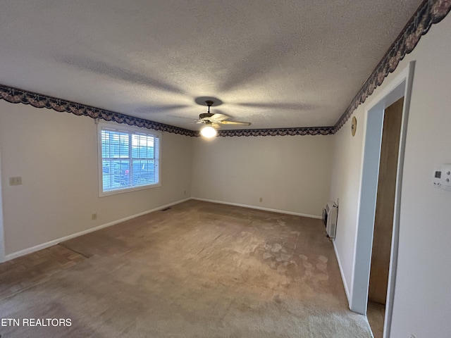 carpeted spare room with a textured ceiling, heating unit, and ceiling fan