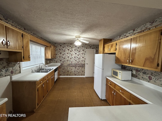 kitchen featuring a textured ceiling, white appliances, ceiling fan, and sink