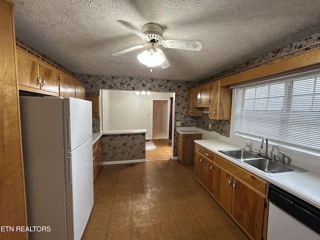 kitchen with a textured ceiling, ceiling fan, white appliances, and sink