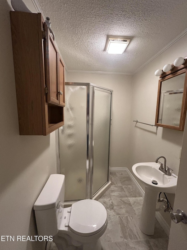 bathroom featuring a textured ceiling, toilet, ornamental molding, and walk in shower