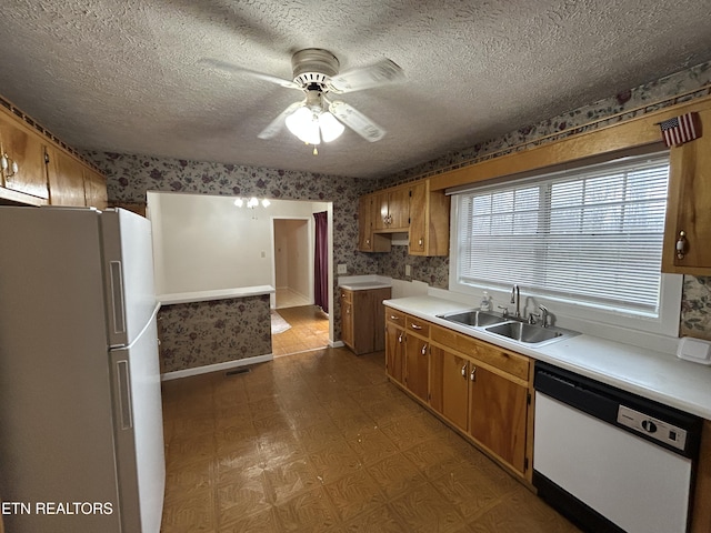 kitchen with a textured ceiling, ceiling fan, white appliances, and sink