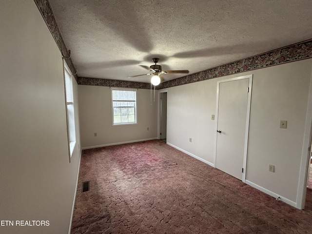 unfurnished bedroom featuring ceiling fan, carpet floors, and a textured ceiling