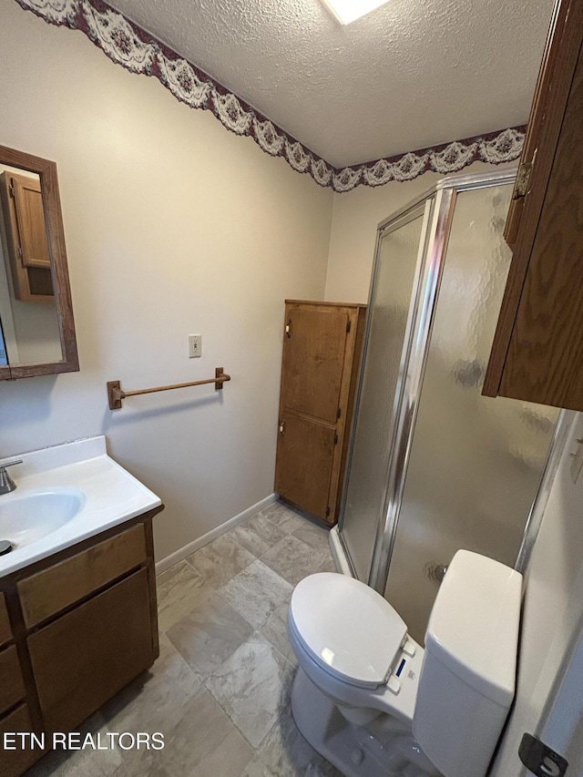 bathroom featuring vanity, a textured ceiling, toilet, and an enclosed shower