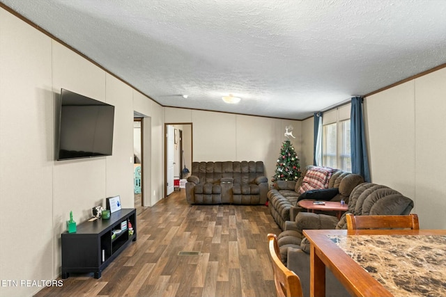 living room with crown molding, a textured ceiling, and dark wood-type flooring