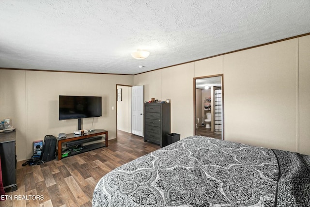 bedroom featuring crown molding, dark wood-type flooring, and a textured ceiling