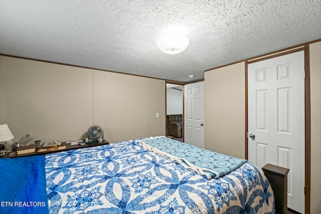 bedroom with crown molding and a textured ceiling