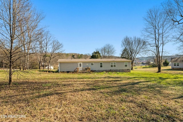 rear view of property featuring a lawn and a wooden deck