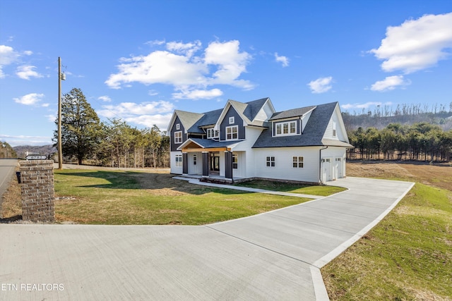 view of front of property featuring a front yard, a garage, and covered porch